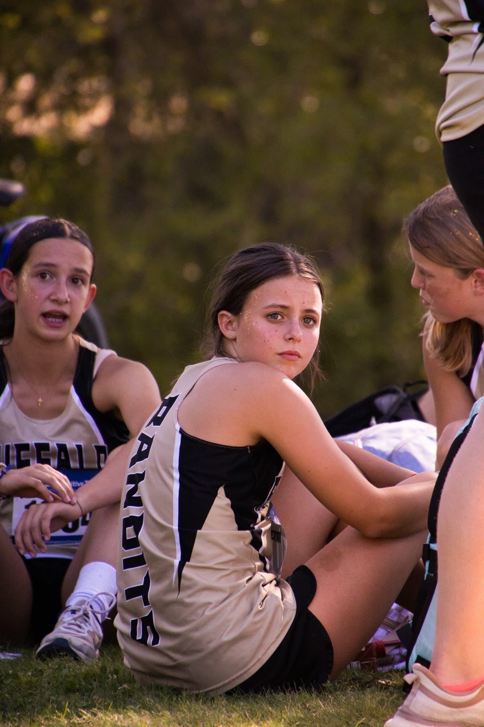 Cross country teammates resting together in the grass after a race