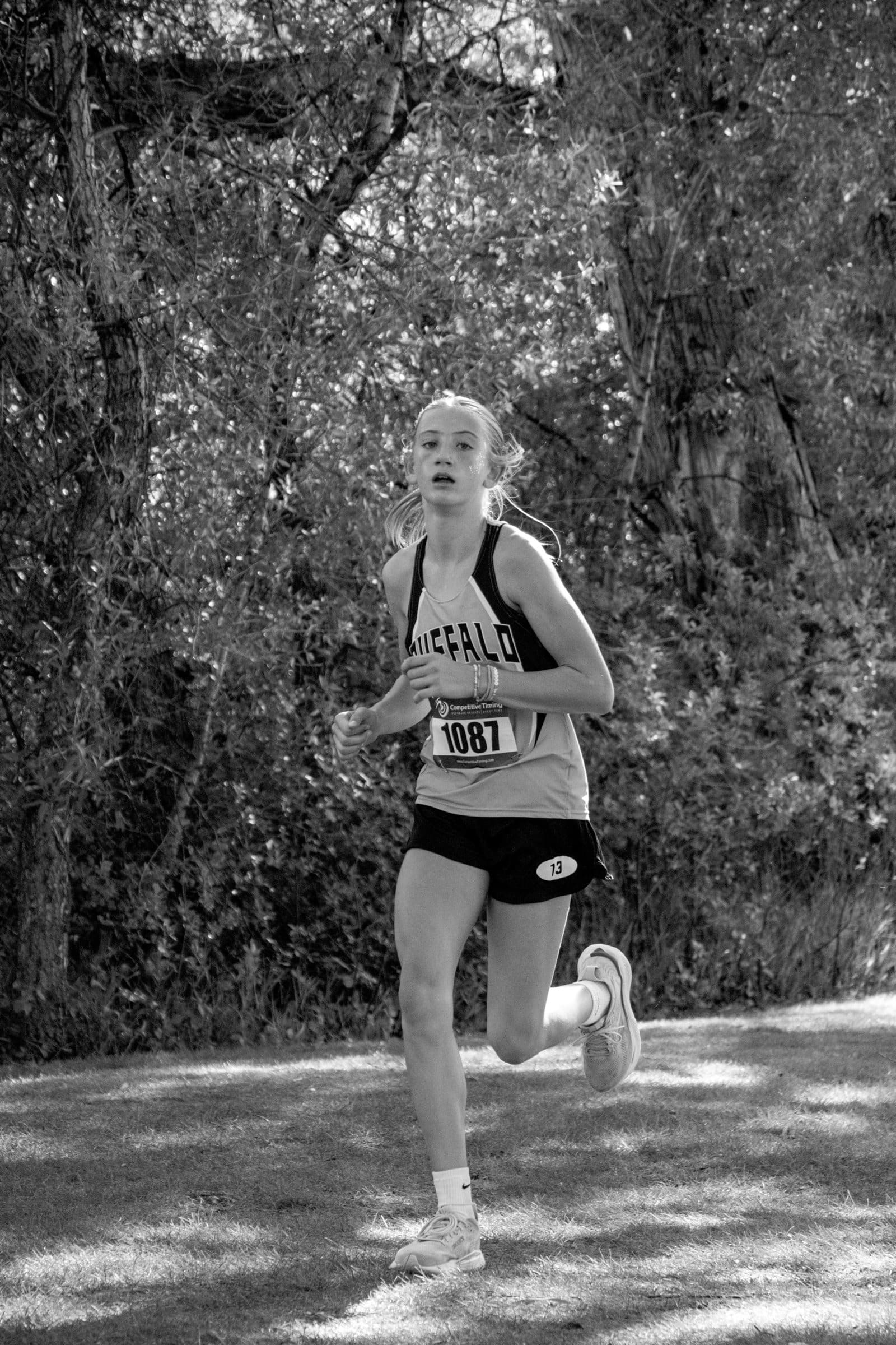 Black-and-white photo of a Buffalo cross country runner mid-stride